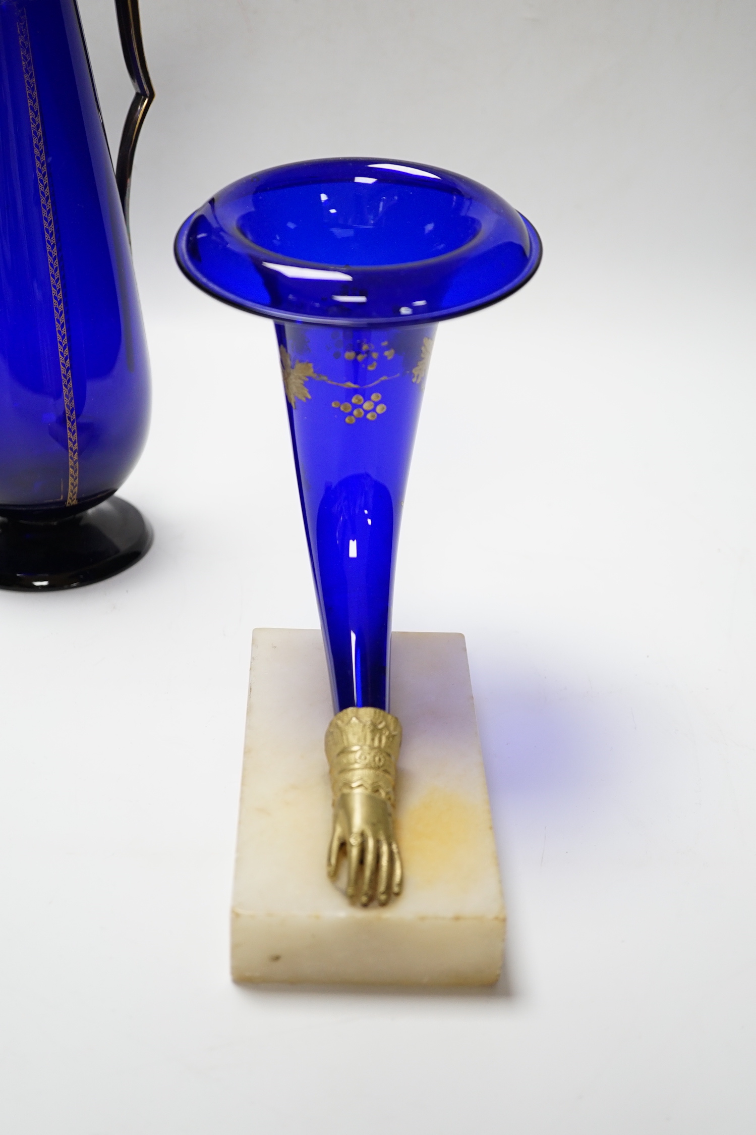 A 19th century Bristol blue cornucopia trumpet with metal hand mount with gilt decoration and a gilt decorated and mounted Bristol blue claret jug, jug 31.5cm high